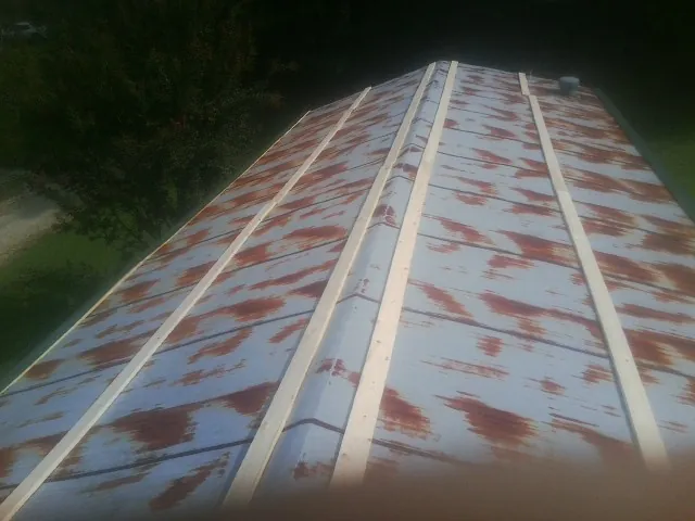 Rusted metal roof panels with new wood purlins before replacement — Storm Damage Roof Repair in Lucerne by Roofing Brothers