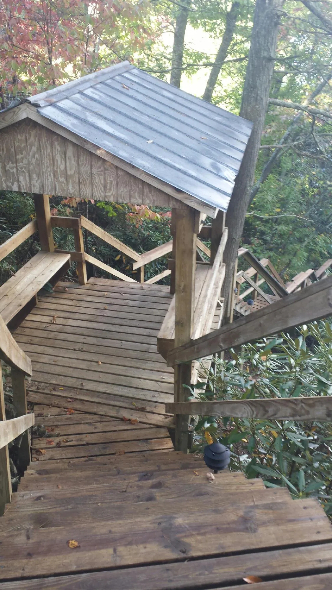Metal roofed shelter over wooden steps on a wooded walkway — Skylight Repair & Installation work by our crew in Lucerne