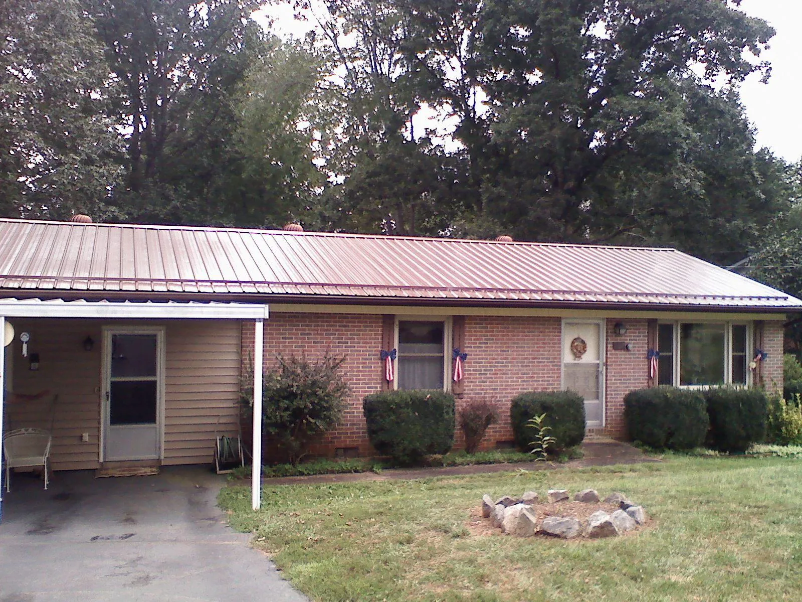 Bronze metal roof and carport on a brick ranch home — Roof Repair work by our crew in Lucerne